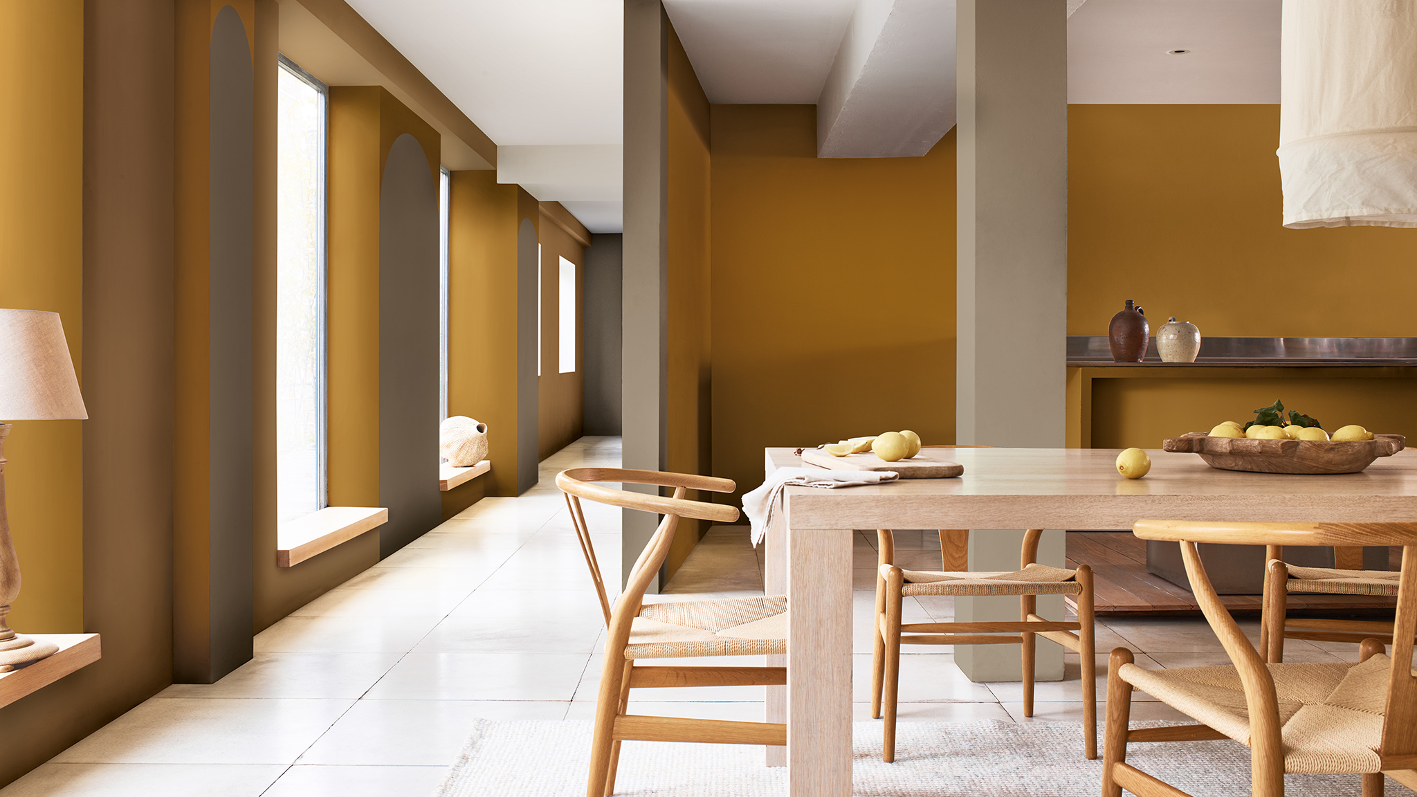 Open plan dining room with wooden table and tall windows on left-hand side Sadolin_CF21_kaip_išdažyti_arką_valgomajame su langais_Lietuva_5