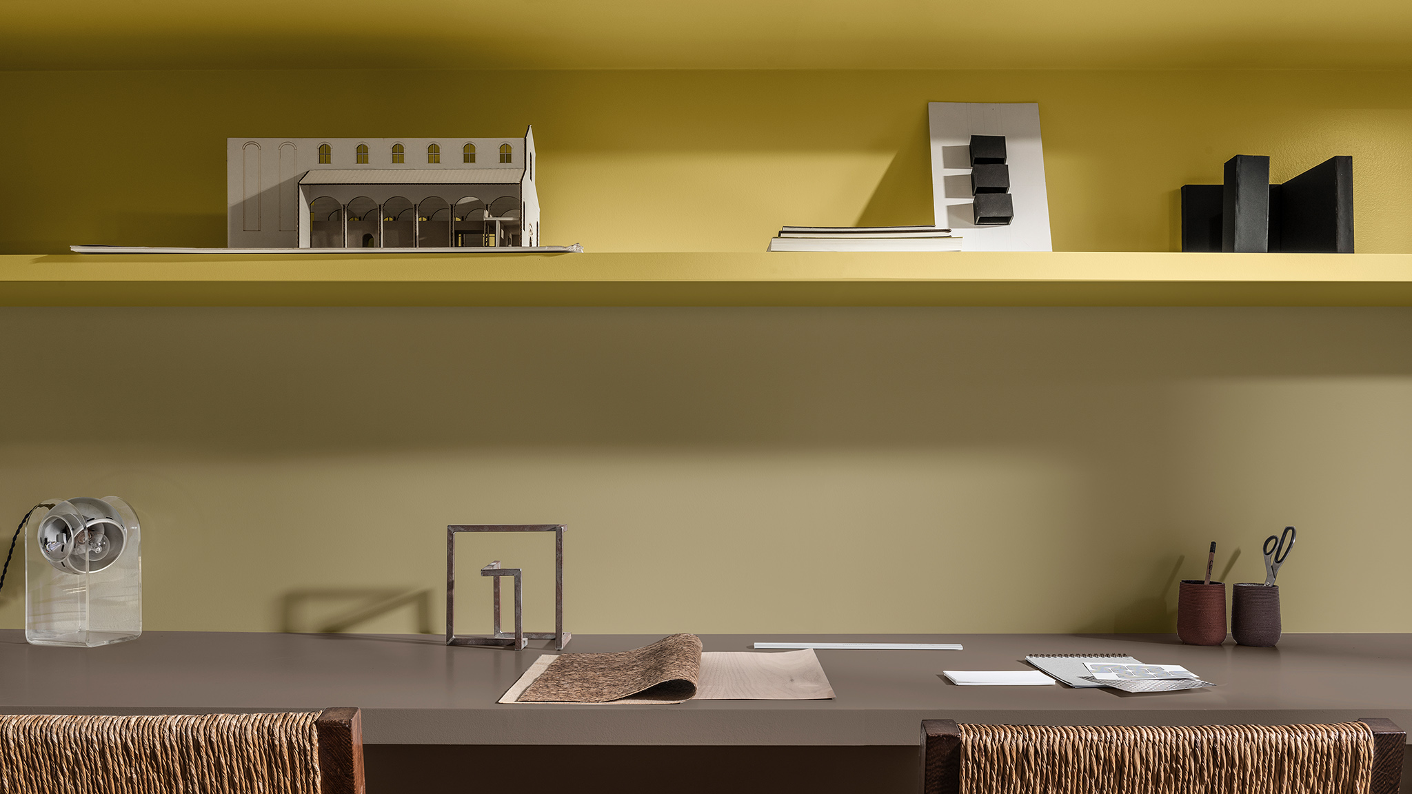 Mokymo lentynos, nudažytos geltonai ir „Brave Ground“, be to, dvi kėdės su austa nugara. „Dulux_CF21_ Colour_of_the_year_Timeless_colors_global_4“