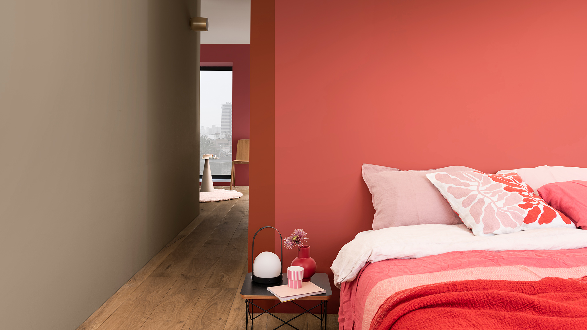 Bed with pink floral cushion against deep pink wall Sadolin_CF21_2021_metų_spalva_Išraiškingos_spalvos_Lietuva_2